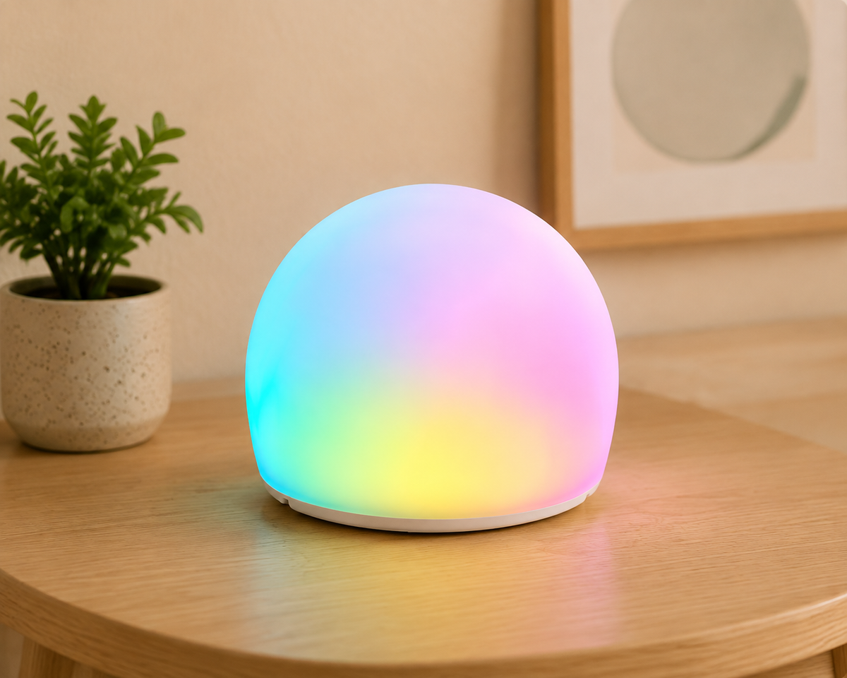 Luna sensory bubble light glowing in soft colours on a wooden table.