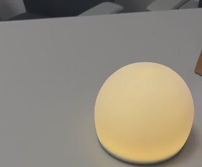 A brief warm-glow preview of the sensory bubble light on a desk.